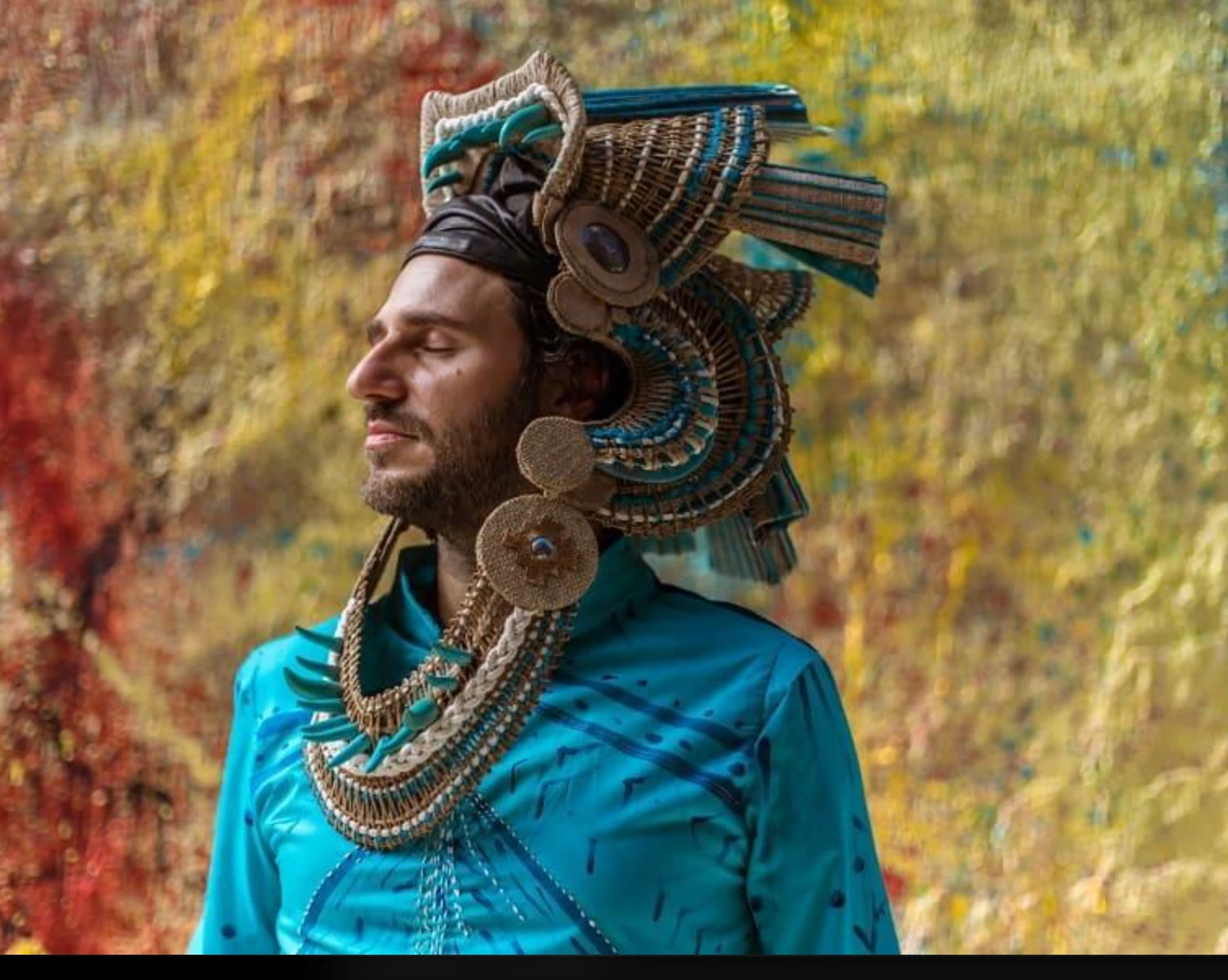 Nación Ekeko, Diego Pérez, con vestuario turquesa y tocado artesanal